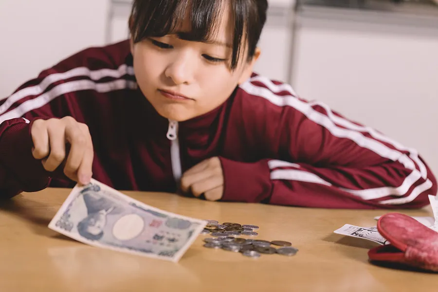 テーブルの上の現金を確認する女性