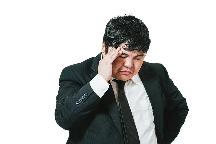 悩んでいるスーツの男性